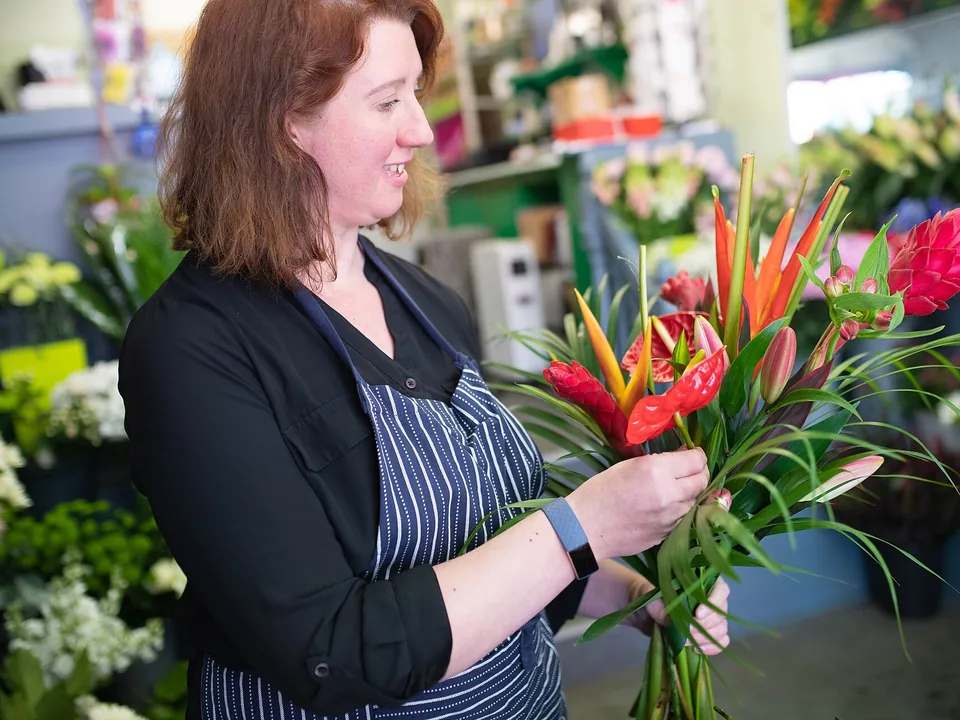 Florista armando un ramo de flores tropicales